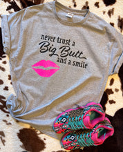 Load image into Gallery viewer, Never trust a big butt and a smile funny graphic tee - Mavictoria Designs Hot Press Express
